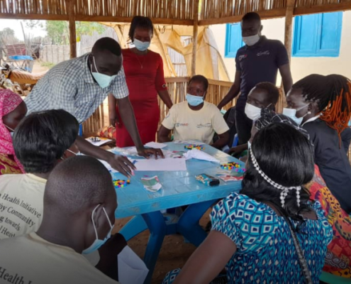 People gather around a table during the design and test phase in South Sudan