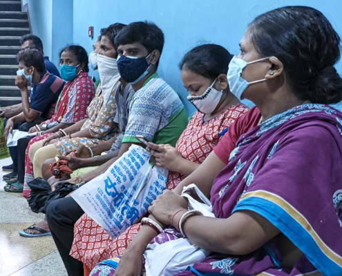People wearing face masks waiting to get the COVID-19 vaccine