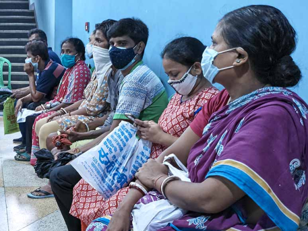 People wearing face masks waiting to get the COVID-19 vaccine