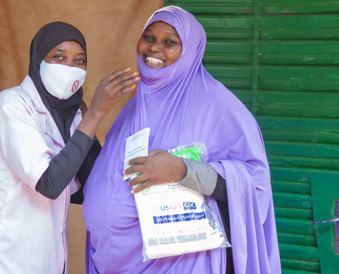 Pregnant woman receives a mosquito net at her prenatal visit