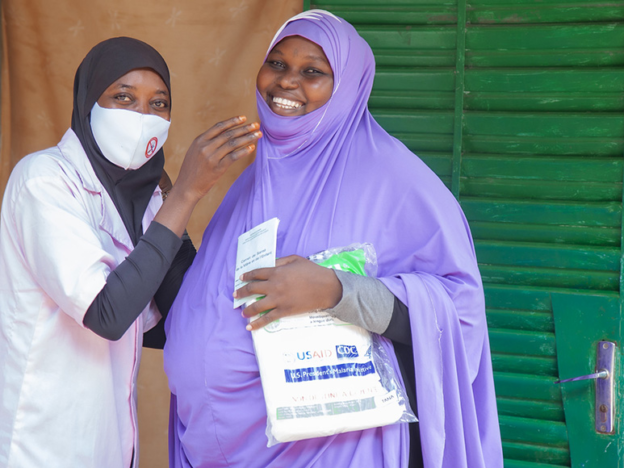 Pregnant woman receives a mosquito net at her prenatal visit