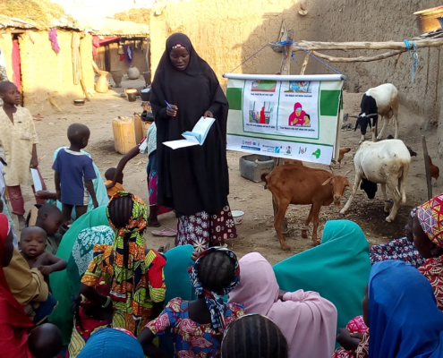 A woman leads a compound meeting in northern Nigeria.
