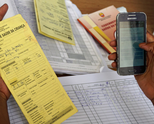 A female health worker uses a mobile app to record vaccination data in Mozambique