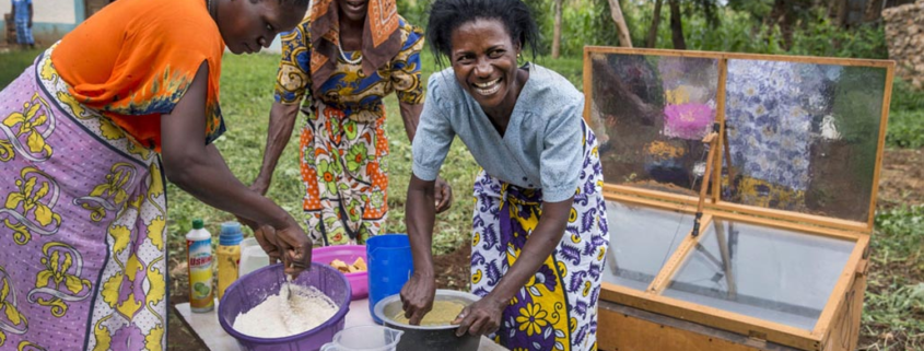 Three women preparing to bake cakes with a solar oven in Mombasa, Kenya